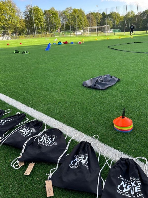 Trainingsmaterial und Taschen am Spielfeldrand